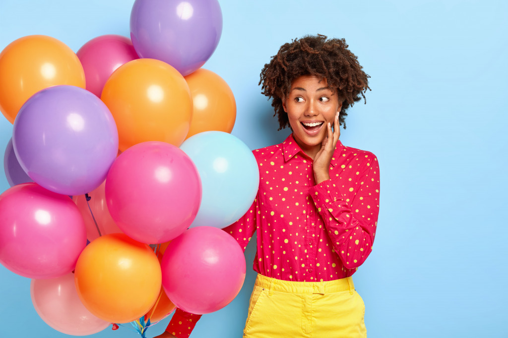 happy woman while looking at her colorful balloons