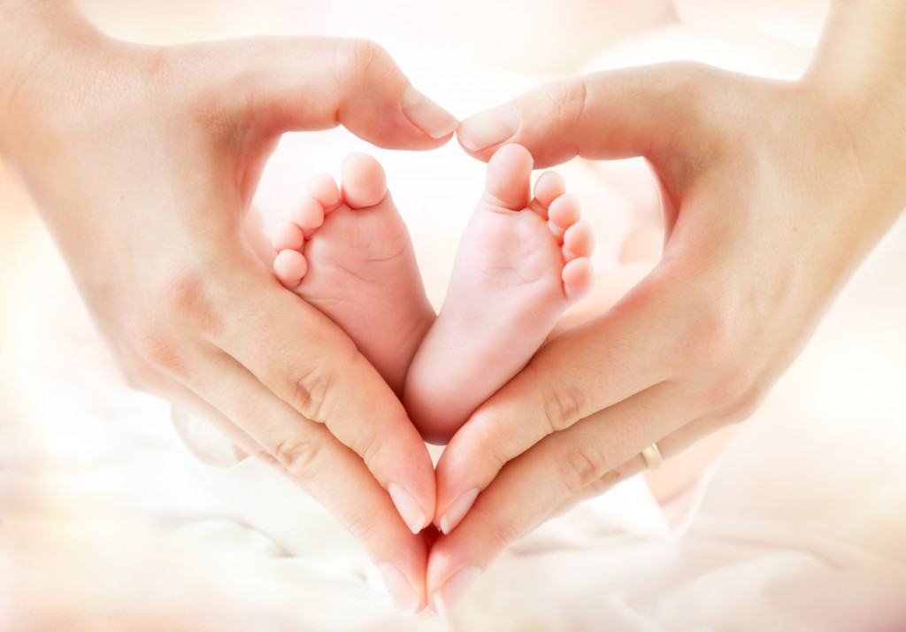 baby feet in mother hands in heart shape
